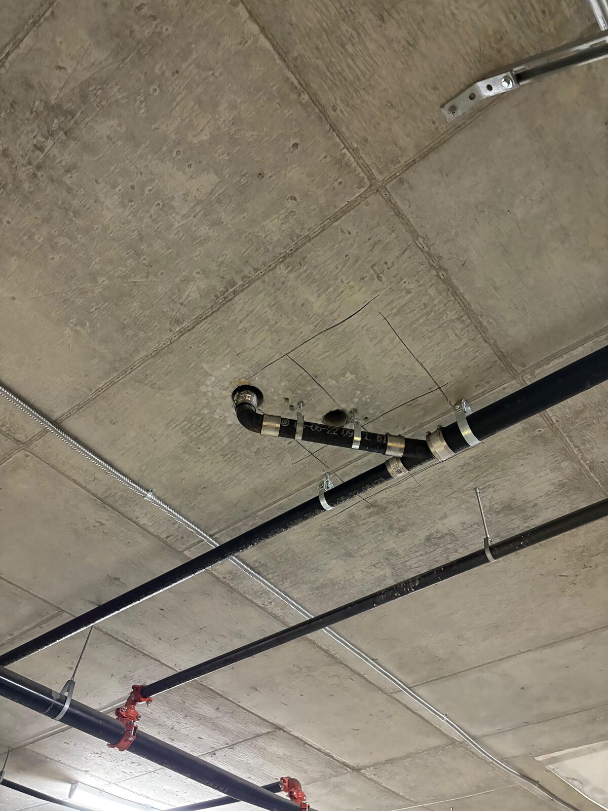 Overhead mechanical piping routed along a commercial ceiling