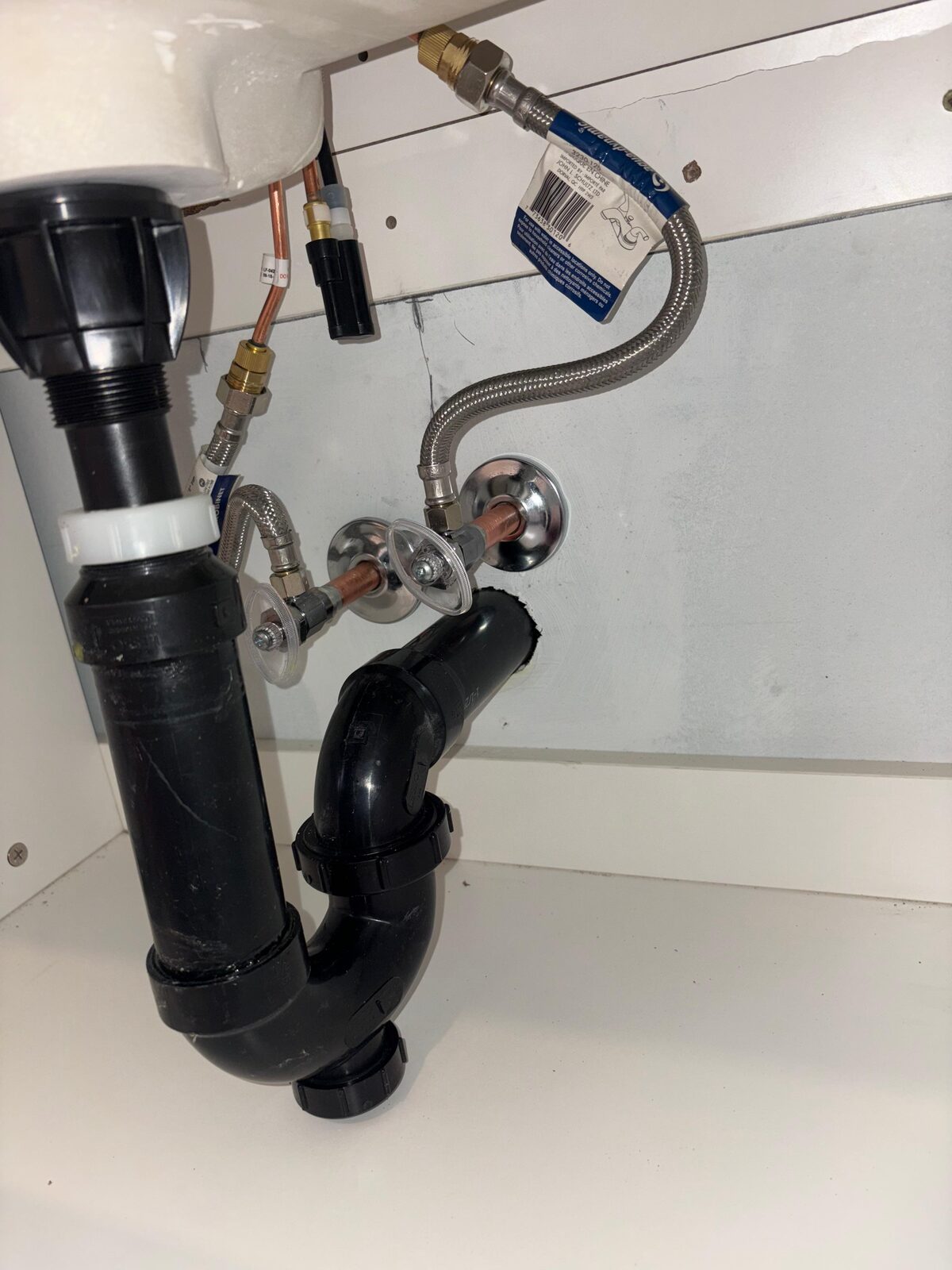 New supply lines and shutoffs plumbed under a bathroom sink